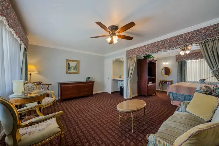 King suite sitting area with a sofa, armchairs and a marble-top table